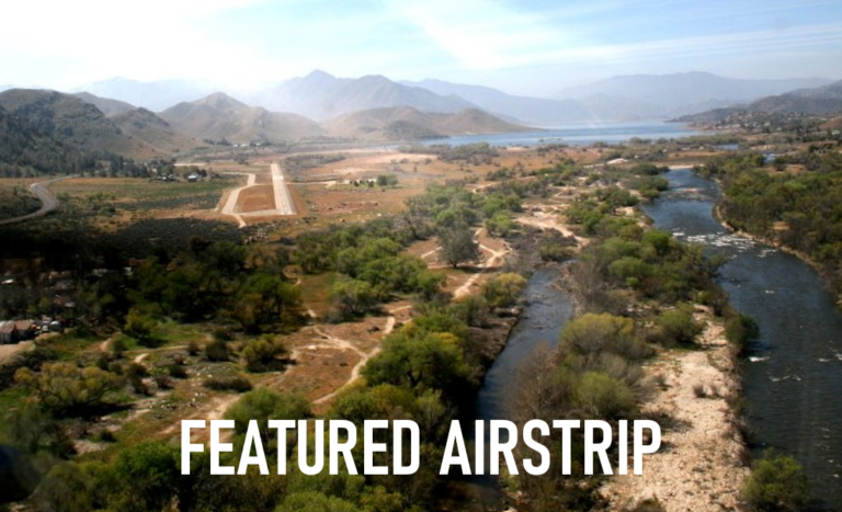 An aerial view of a river surrounded by trees and mountains.