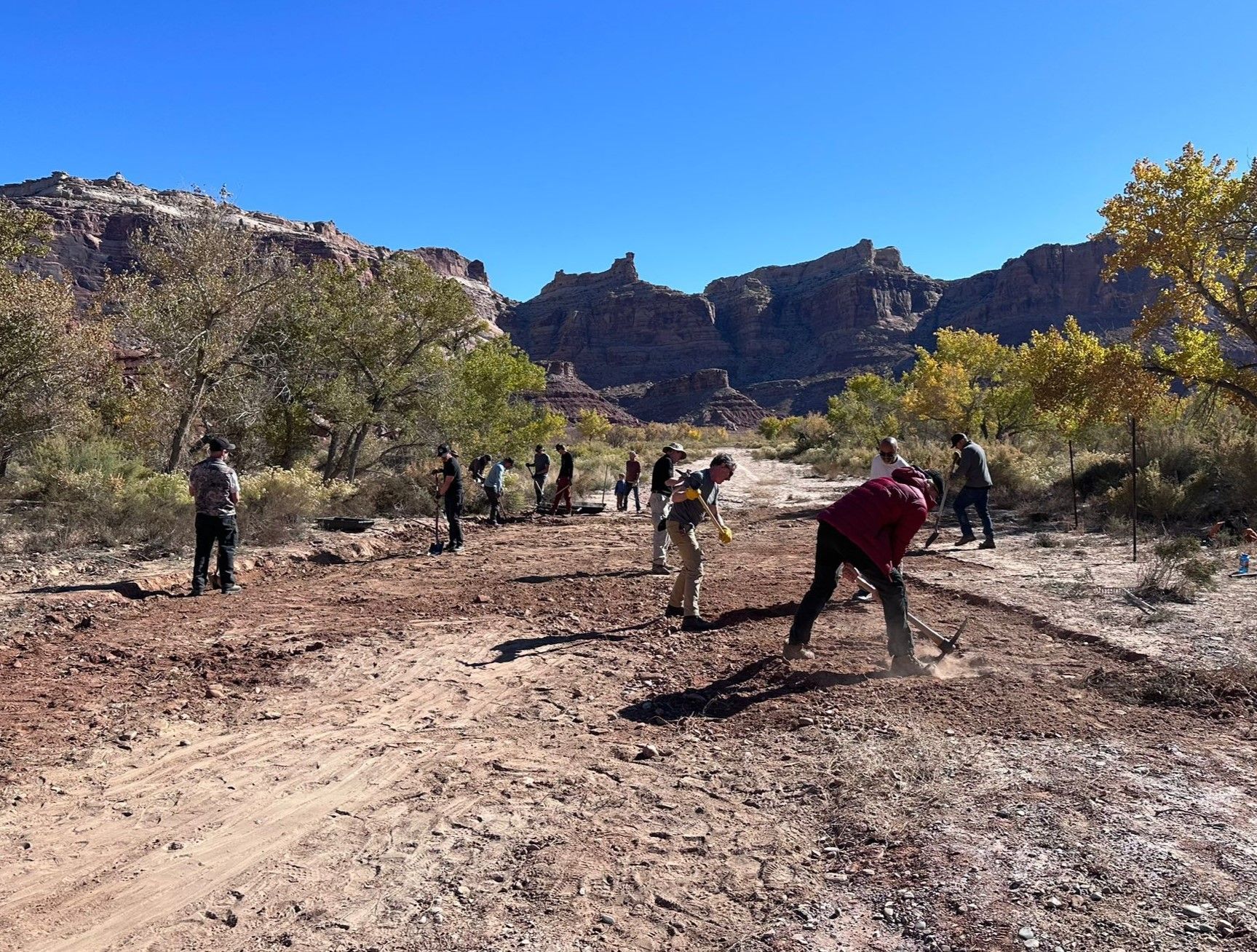 A group of people are working on a dirt road