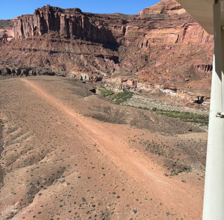 A dirt road in the desert with mountains in the background