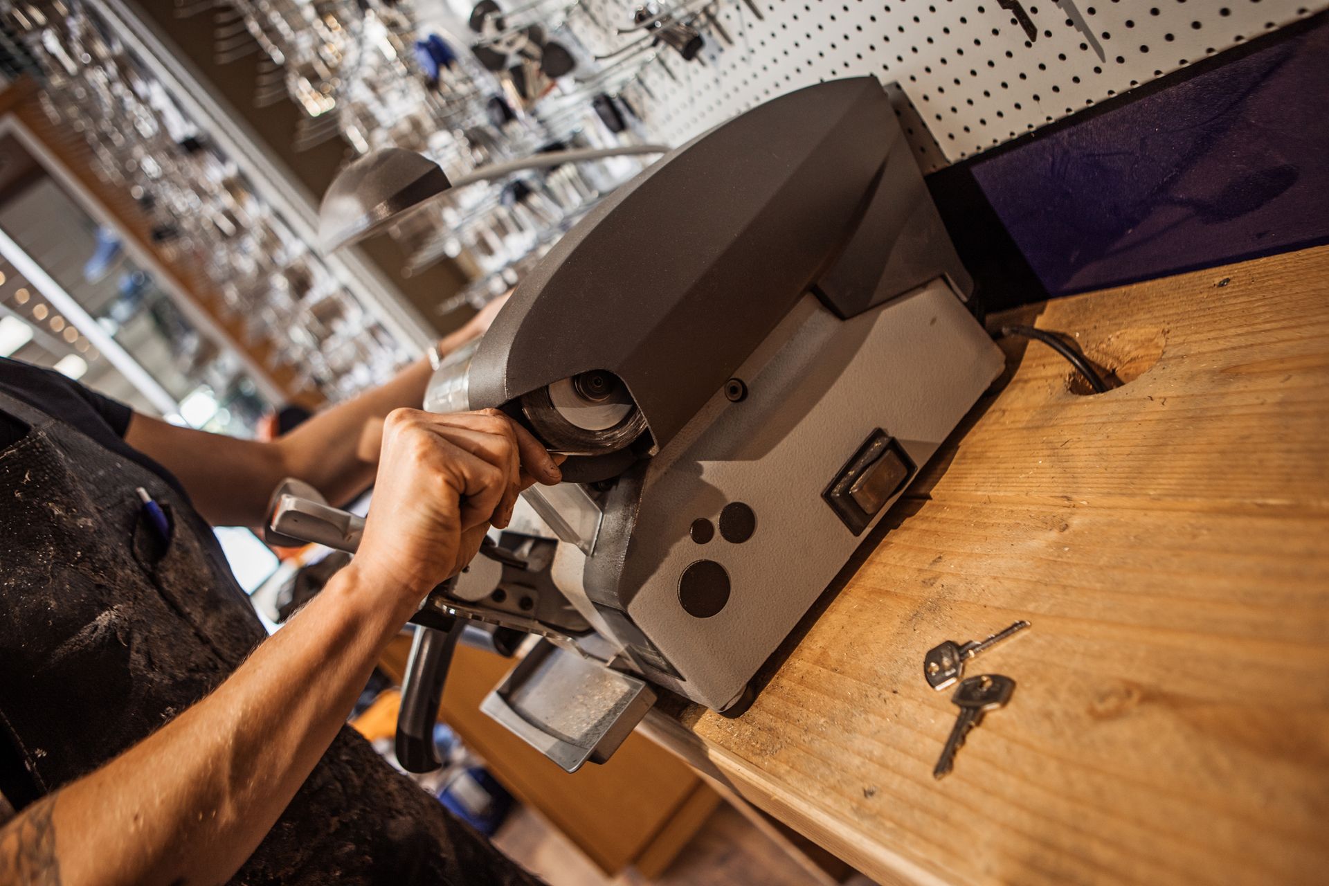 A locksmith working in a store cutting keys.