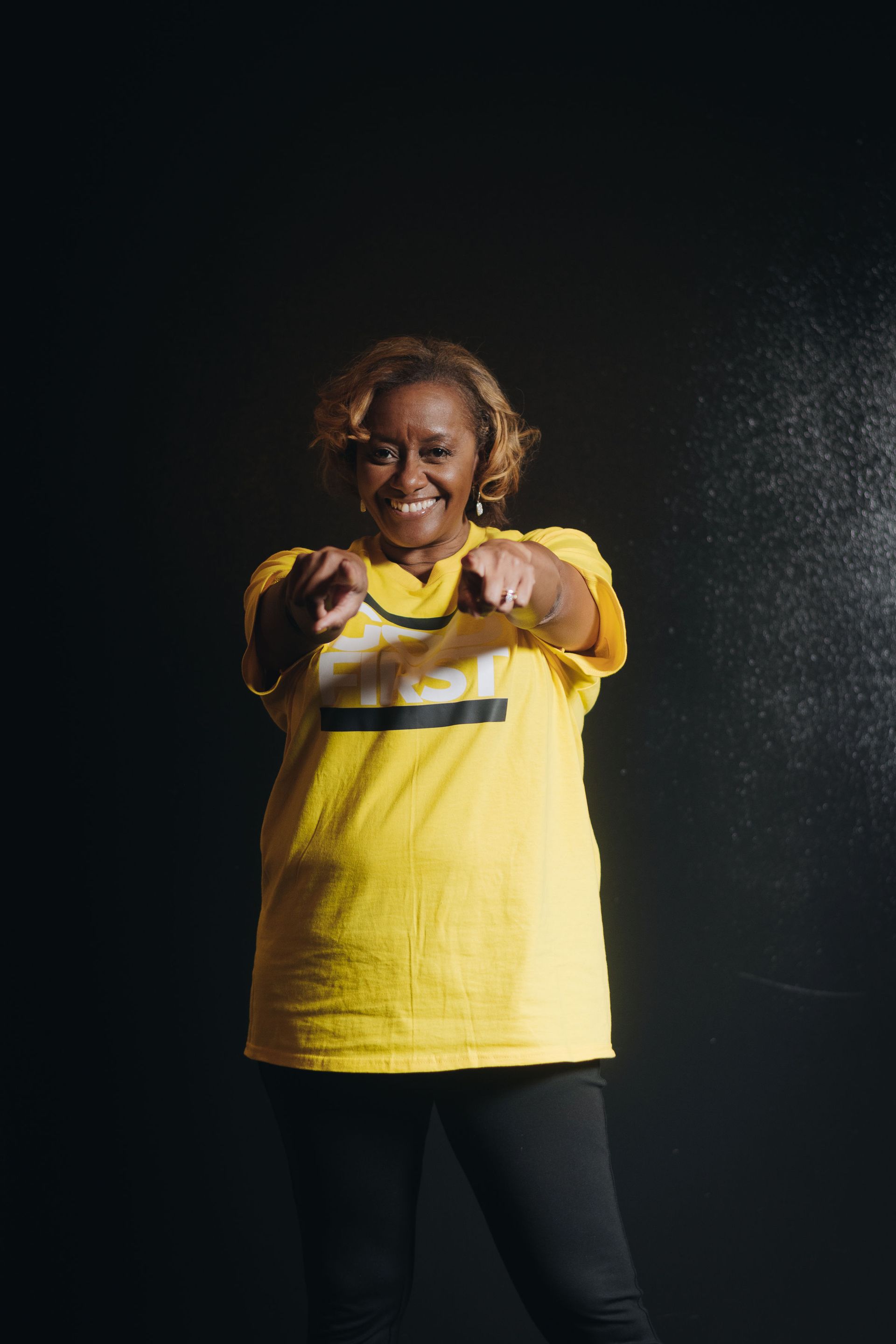 A Woman Wearing a Black Shirt that Says God First