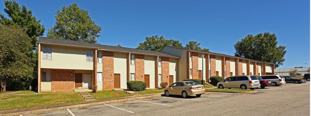 A large apartment building with cars parked in front of it.