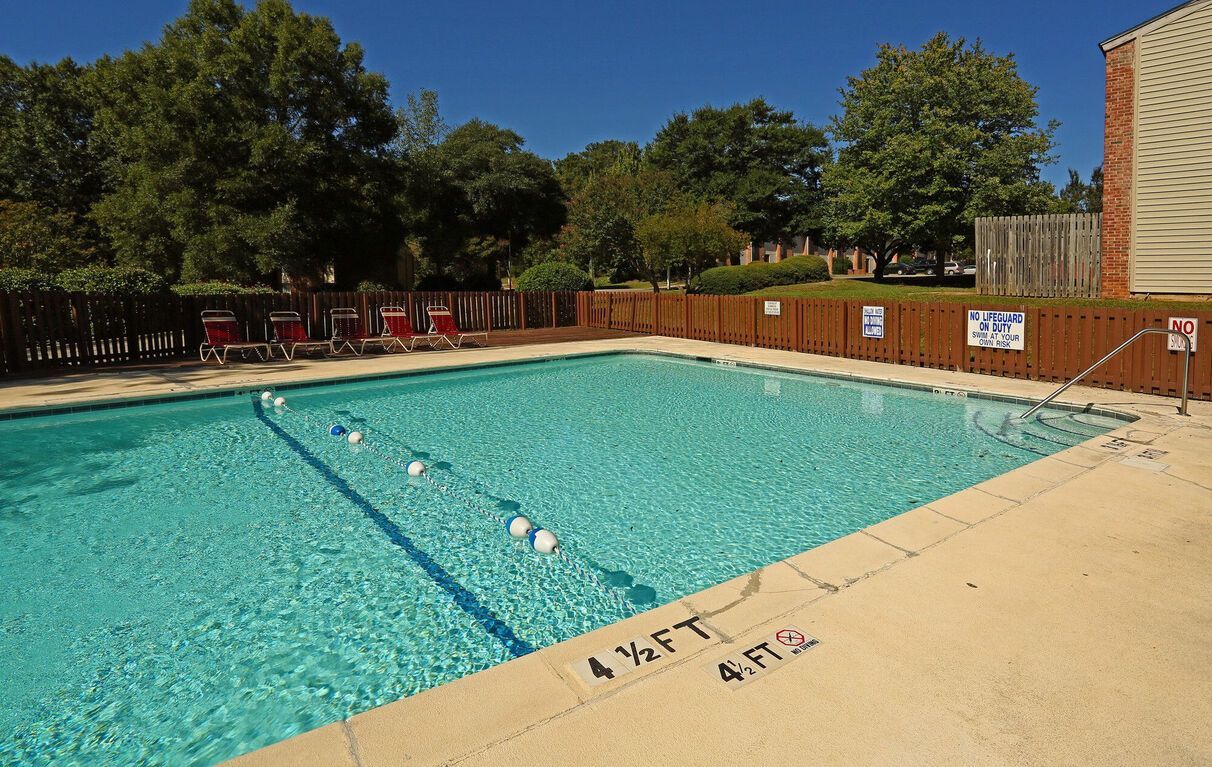 A large swimming pool with a wooden fence around it