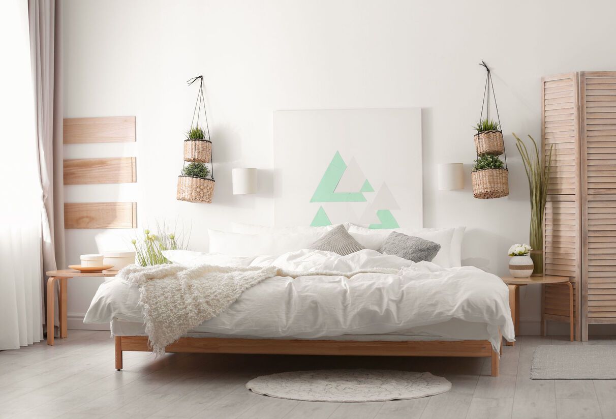 A bedroom with a bed and a painting on the wall.