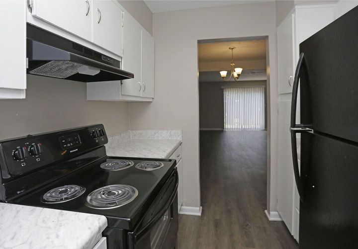 A kitchen with a black stove top oven and a black refrigerator