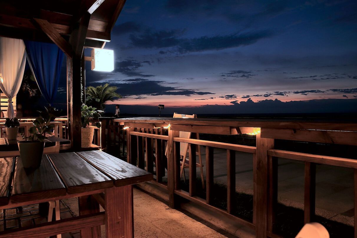 A balcony with a view of the ocean at night.