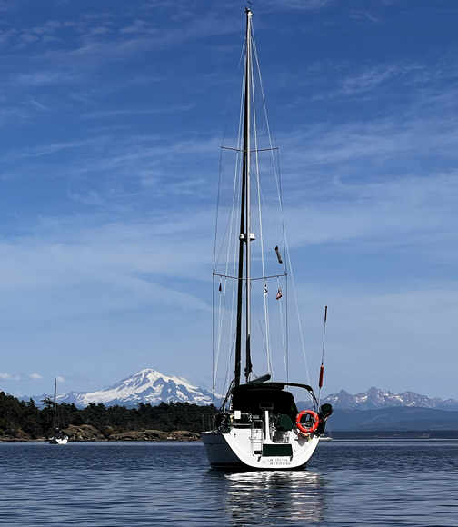 A sailboat in the water with mountains in the background