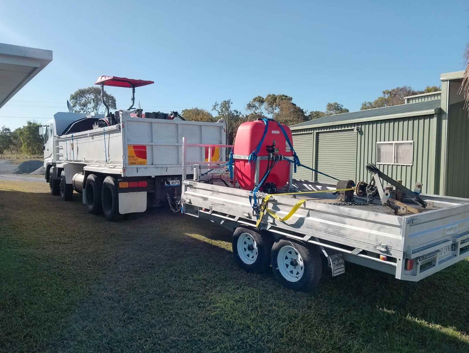A Truck With a Trailer Attached to It is Parked in a Grassy Area — CQ Rural Services In Bakers Creek, QLD