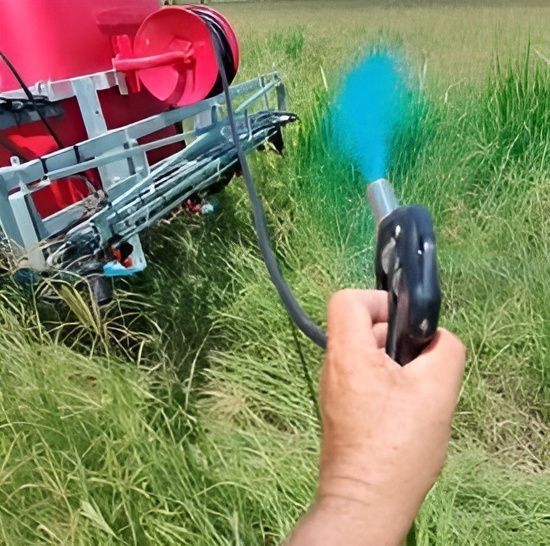 A Person is Spraying a Field With a Sprayer — CQ Rural Services In Bakers Creek, QLD