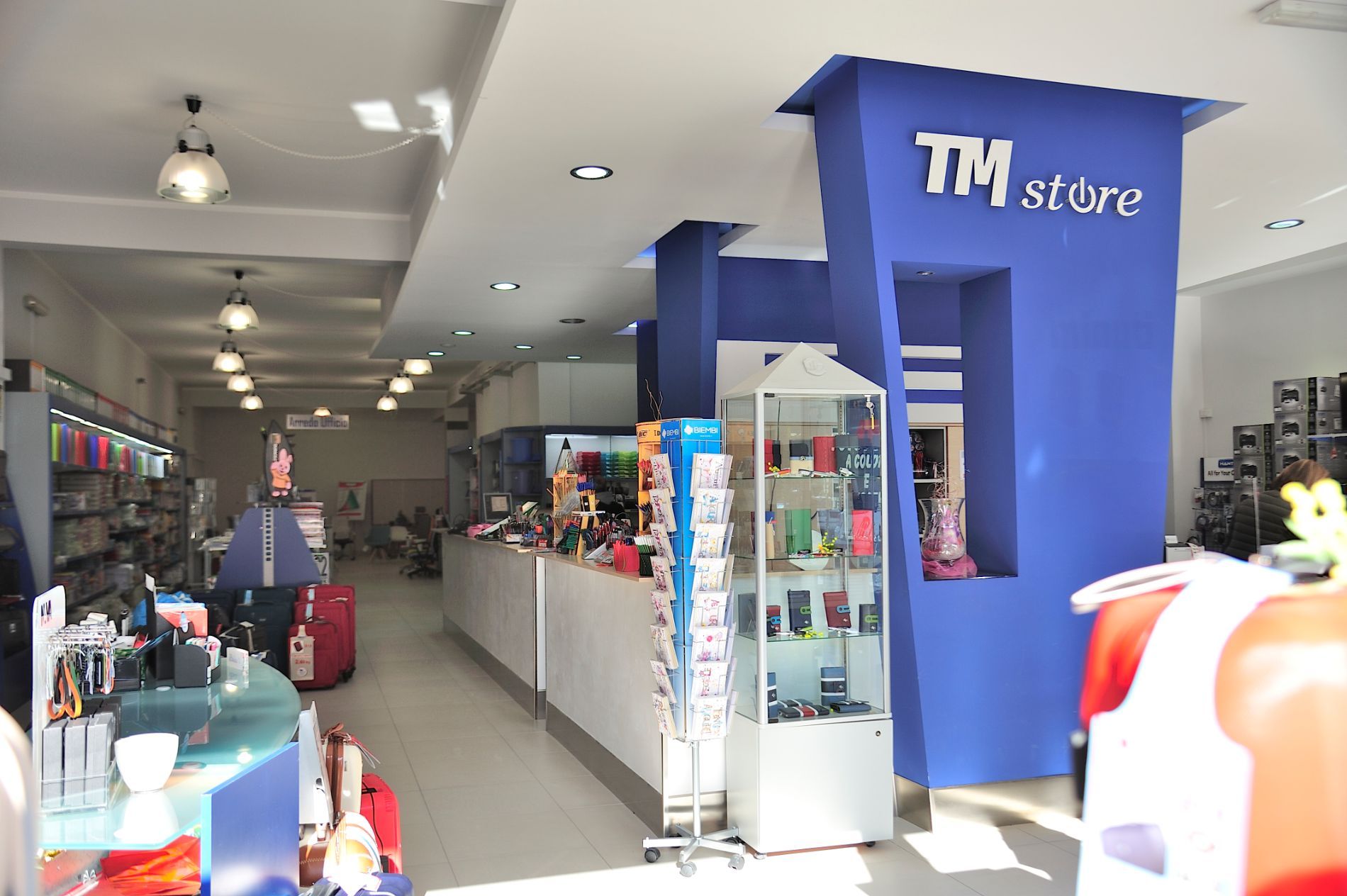 Interno del negozio TM, esposizione della merce, dettagli blu, illuminazione dall'alto.