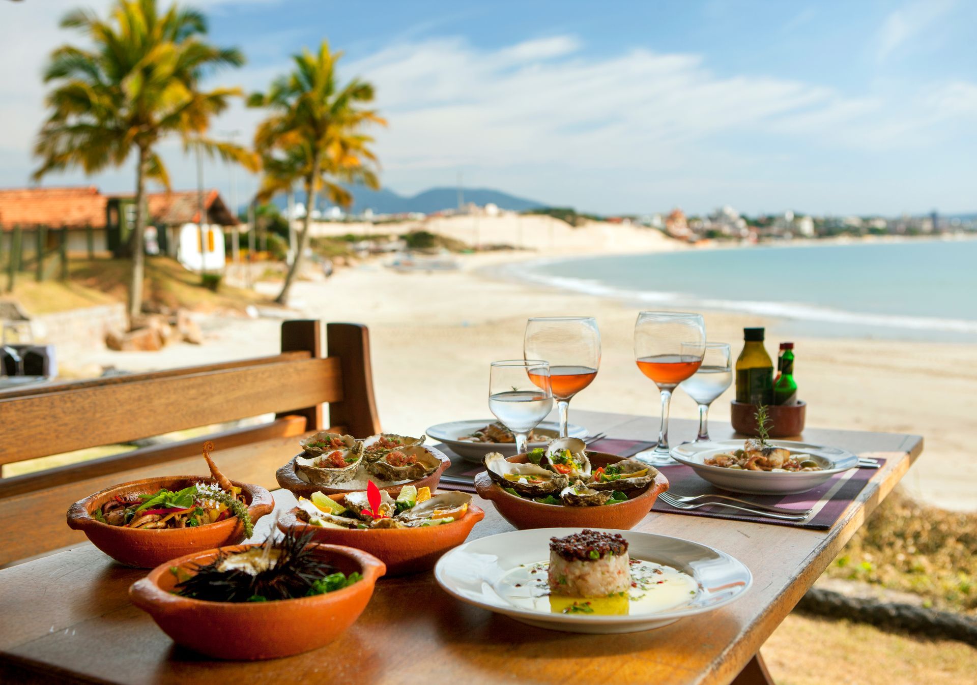 table with seafood dishes with beach background