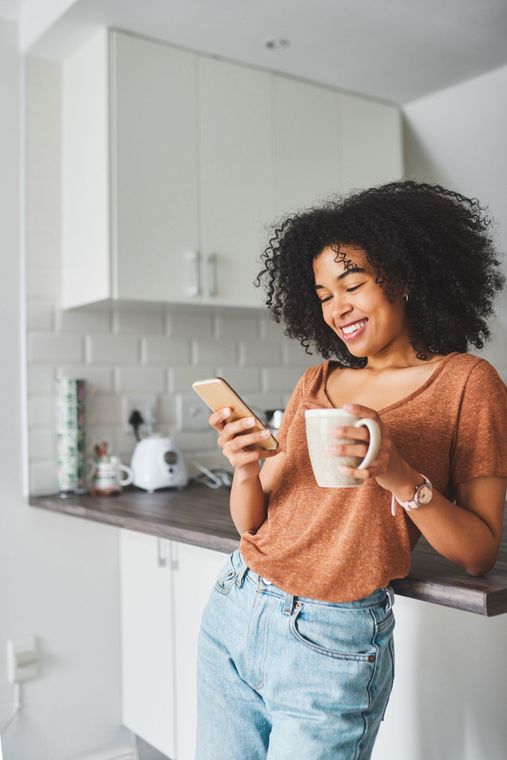 Photo of a Women Texting & Drinking Coffee