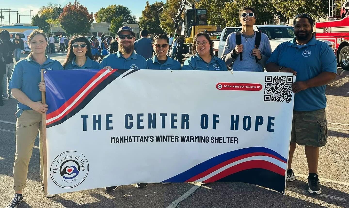 Team holding up Center Of Hope Sign