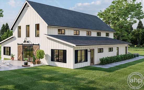 A modern white farmhouse with black trim, a large dark roof, and sliding barn-style doors on a grassy lawn.