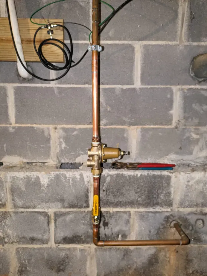 A copper pipe with a yellow valve attached to it