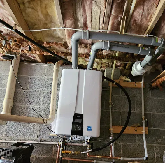 A white water heater is attached to a brick wall