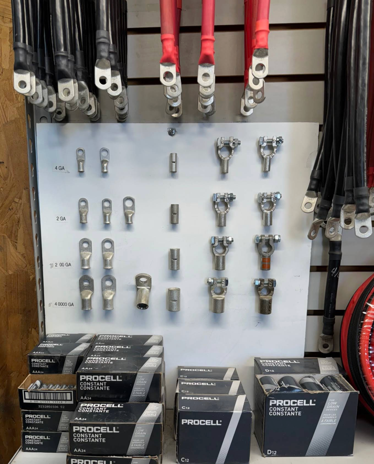 A bunch of wires are hanging on a wall in a store.