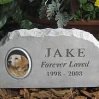 A memorial stone for a pet named Jake with a photo of a golden retriever, inscribed 