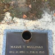 A bronze grave marker on a granite base, reading: 