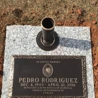 A grave marker for Pedro Rodriguez, born Dec. 4, 1945, died April 21, 2016, with a central vase on a granite base.