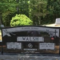 A black granite headstone for the Walsh family in a cemetery, featuring names and dates for Benjamin E. and Margie McGee.