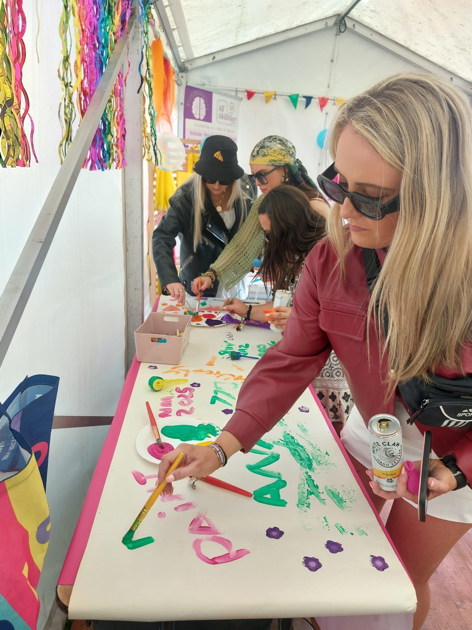women paint a poster with colored paints
