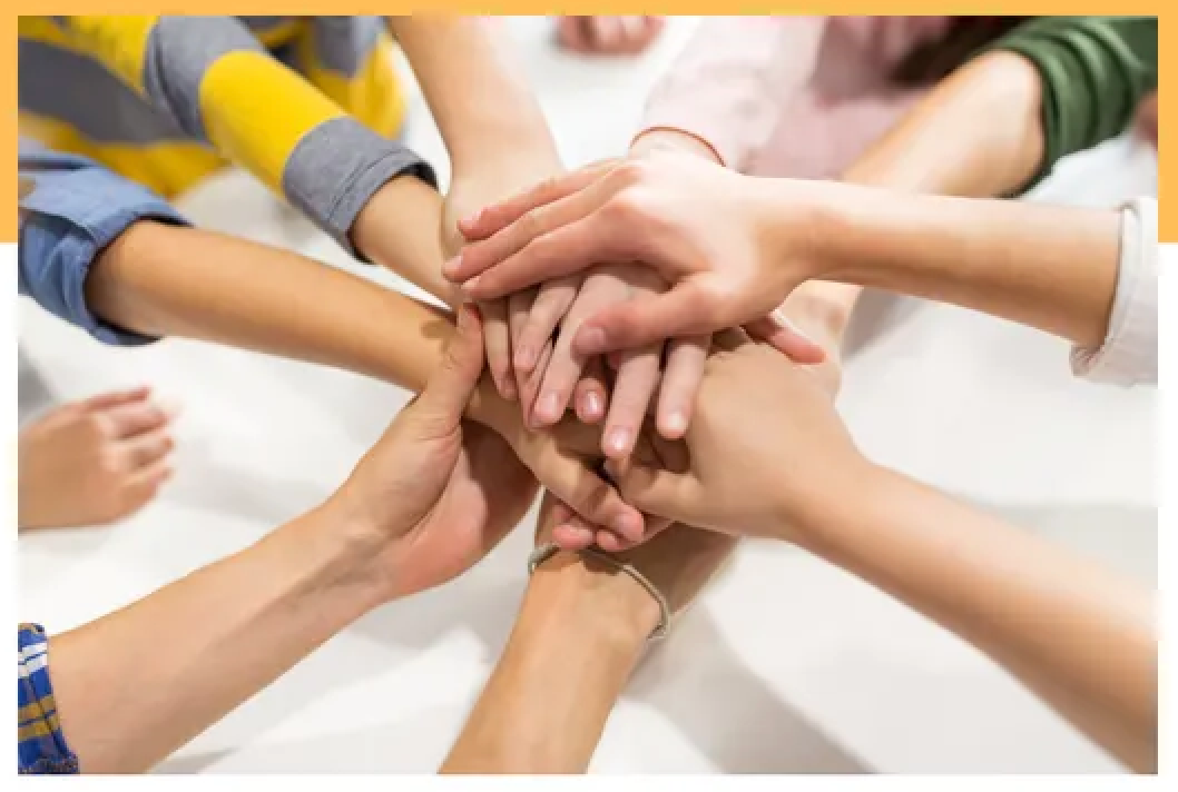 Hands stacked in a team unity gesture