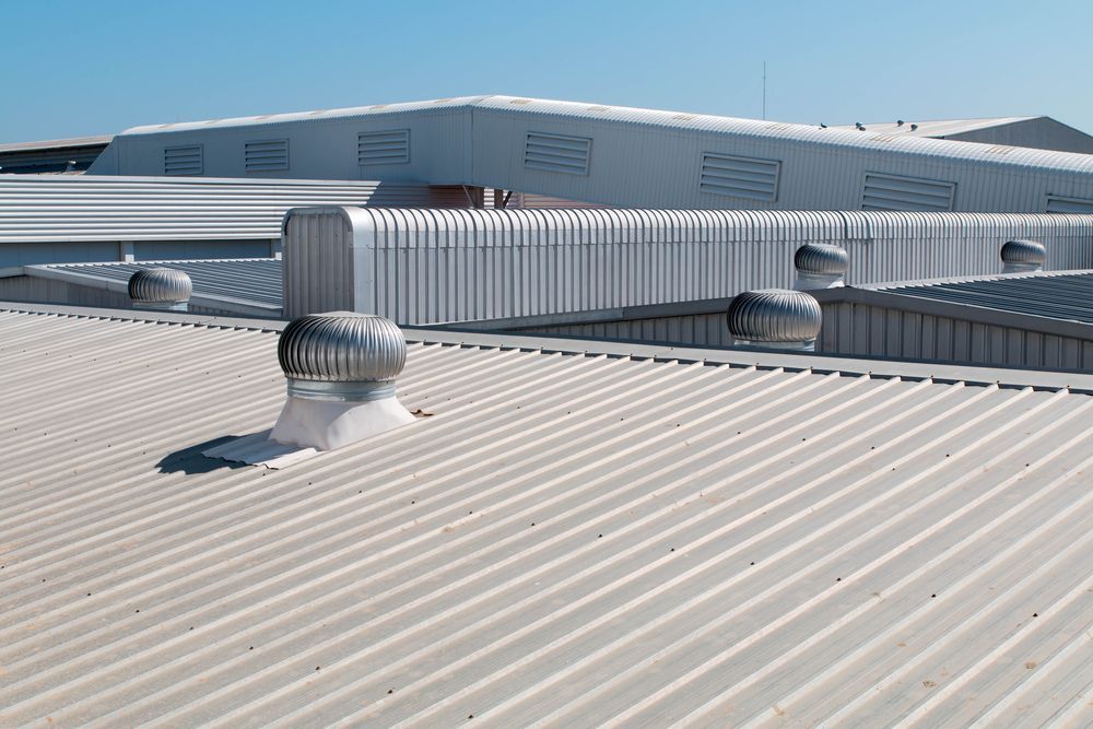 Industrial Building Roof With Corrugated Metal and Several Rotating Vent Fans — Vision Roofing Fascia & Gutter in Howard, QLD