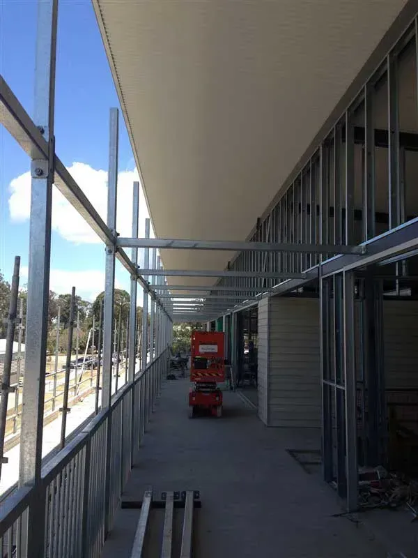 Metal Scaffolding Along a Building's Exterior With a Lift — Vision Roofing Fascia & Gutter in Hervey Bay, QLD