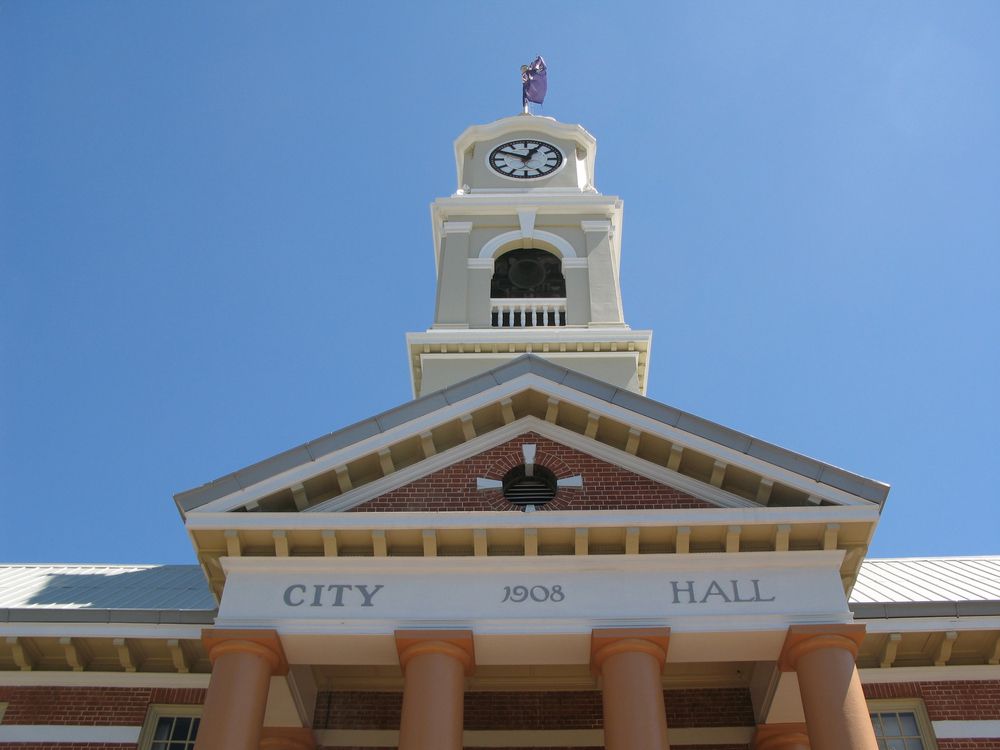 City Hall Building With Clock Tower, Brown Columns, and Brick Facade — Vision Roofing Fascia & Gutter in Maryborough, QLD