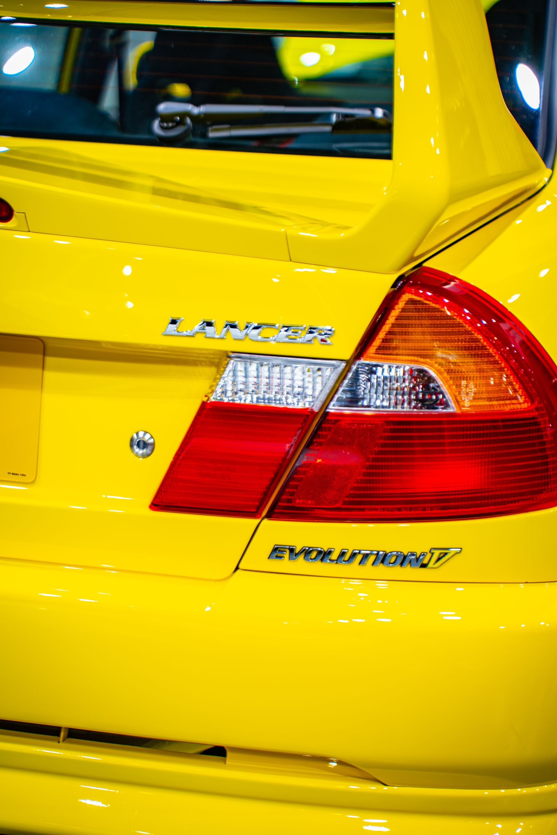 Yellow Mitsubishi Lancer Evolution VII, rear view, with 
