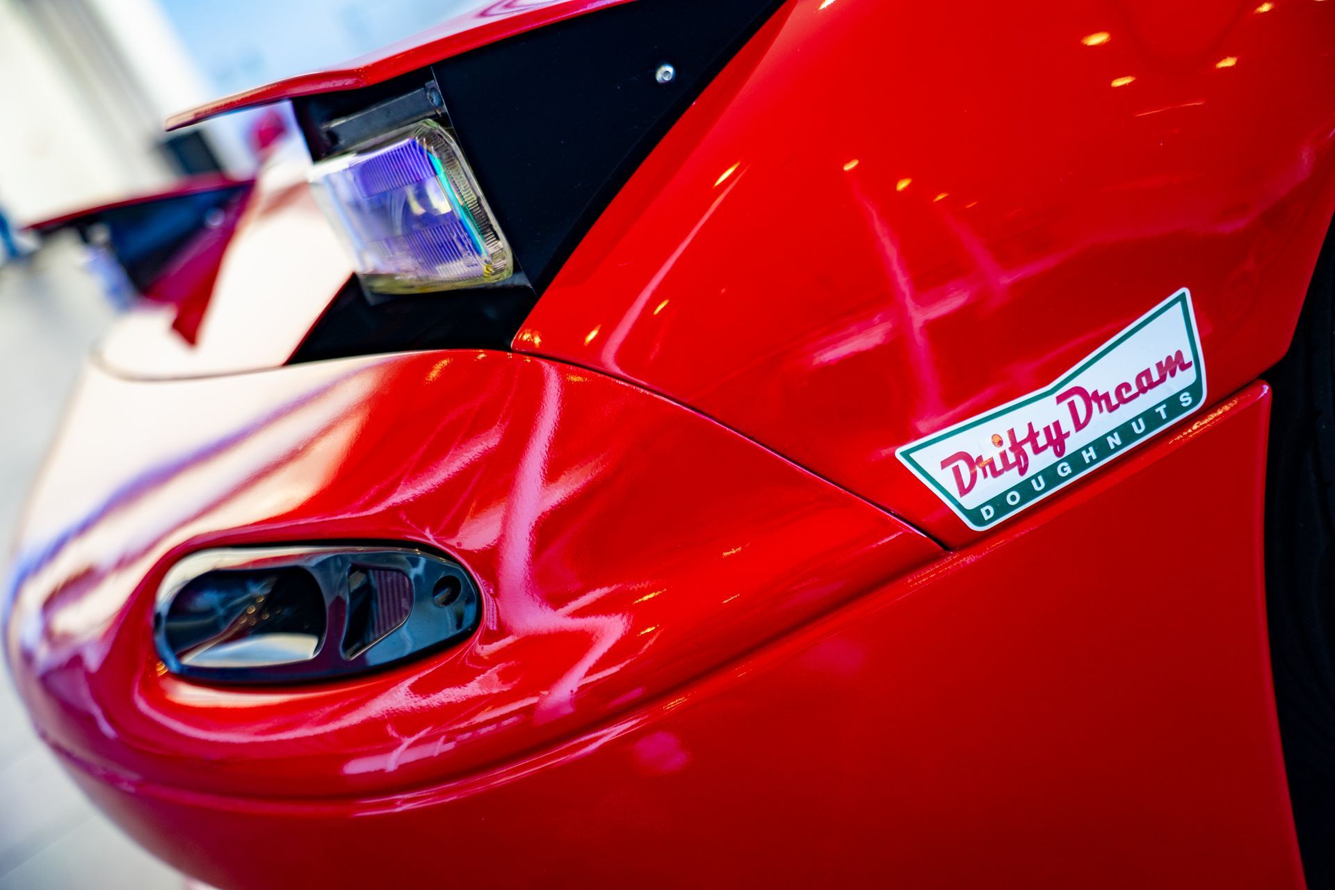 Red sports car close-up with pop-up headlight and 