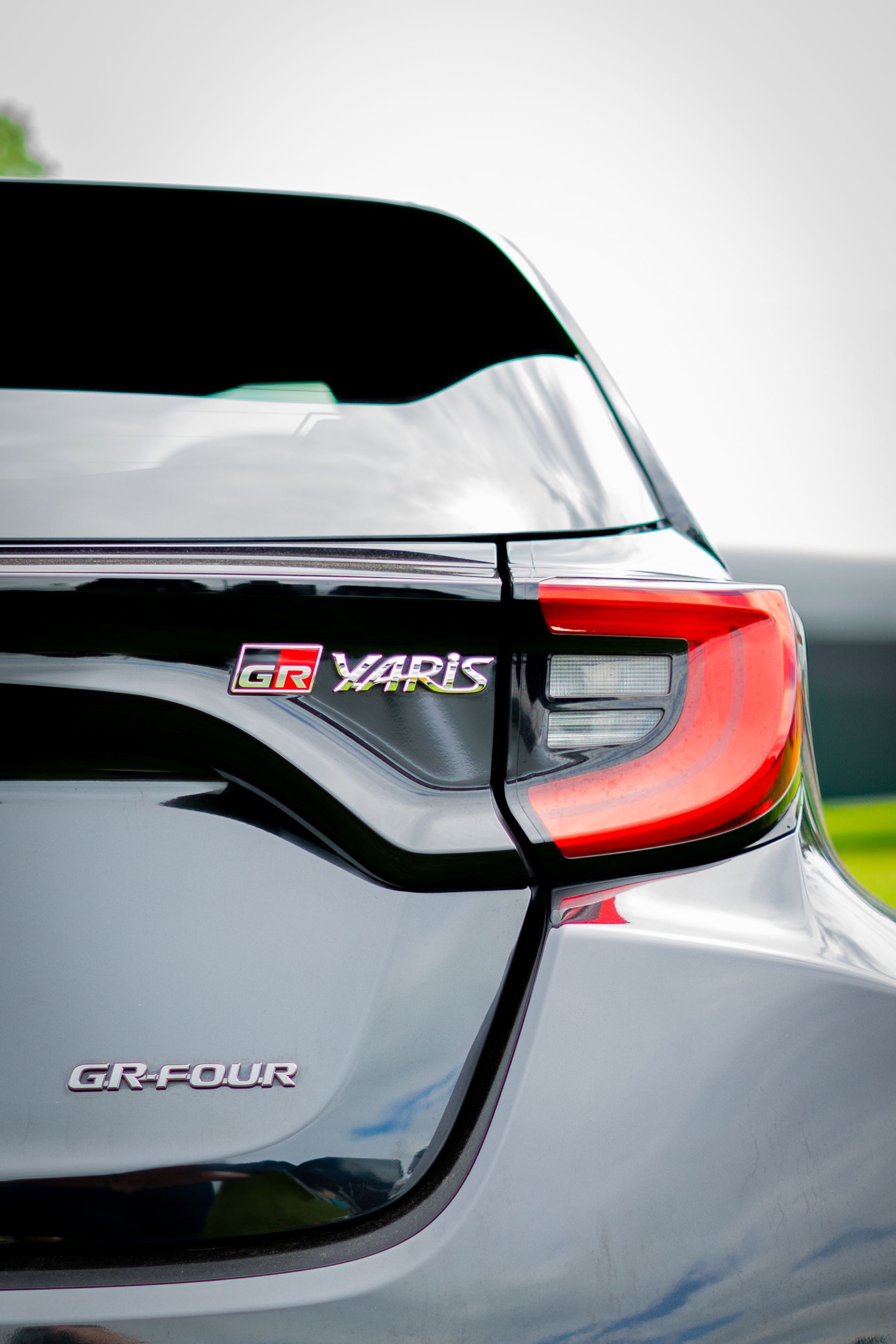 Close-up of black Toyota GR Yaris rear. Red taillight and 
