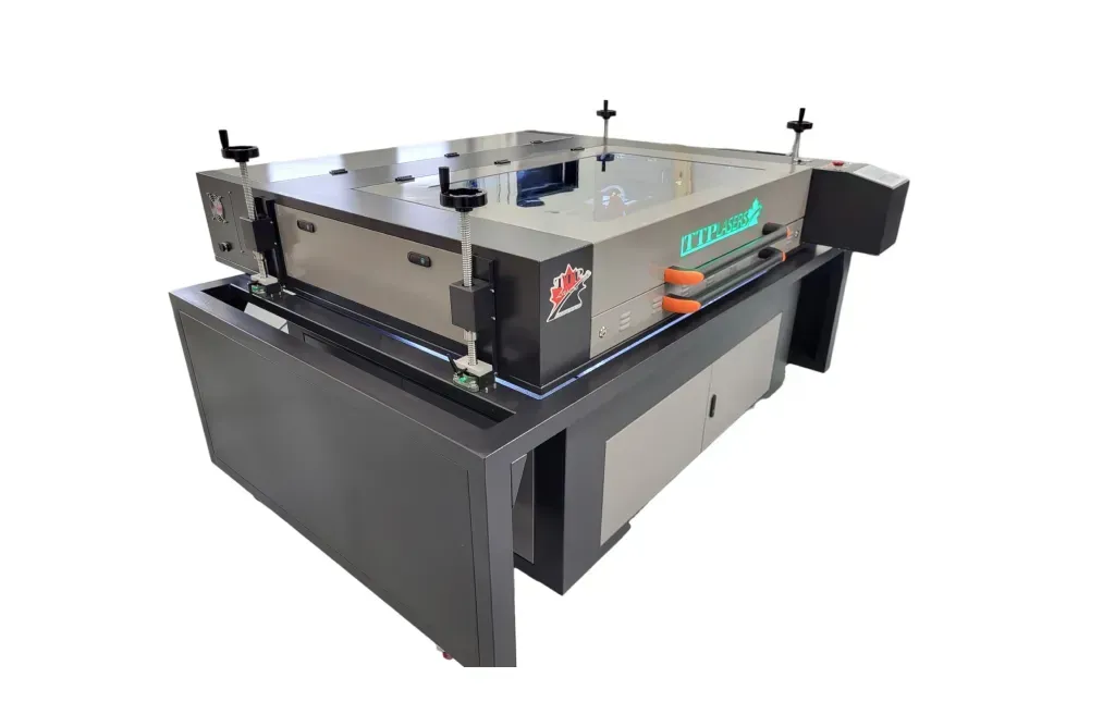 Industrial laser cutting machine, silver and black, with safety guards, positioned on a dark gray cabinet.