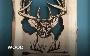 Wood-burned buck head with antlers, cut out of wood, filled with blue resin; a rustic, artistic sign.