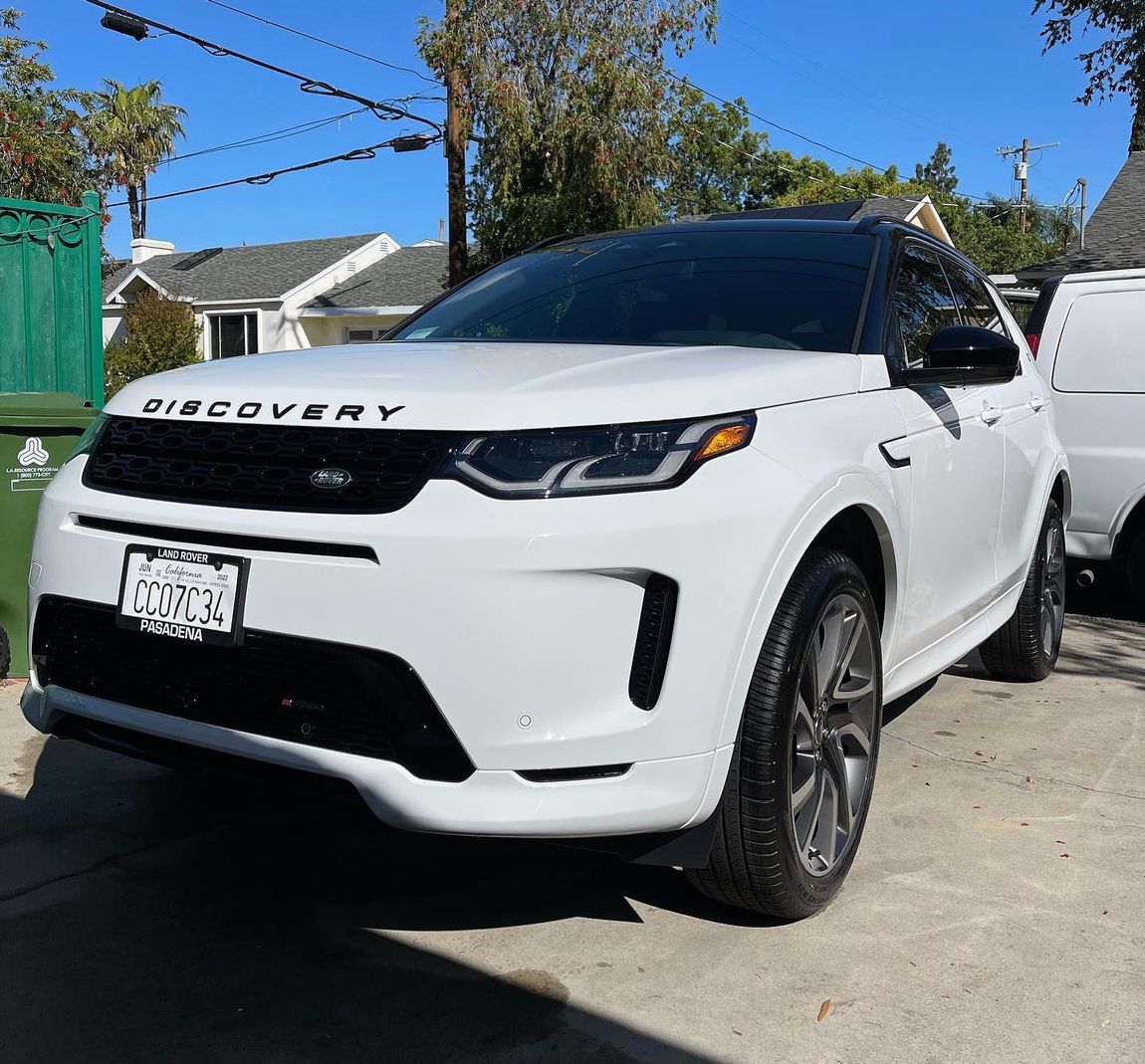 A white land rover discovery is parked in a parking lot.