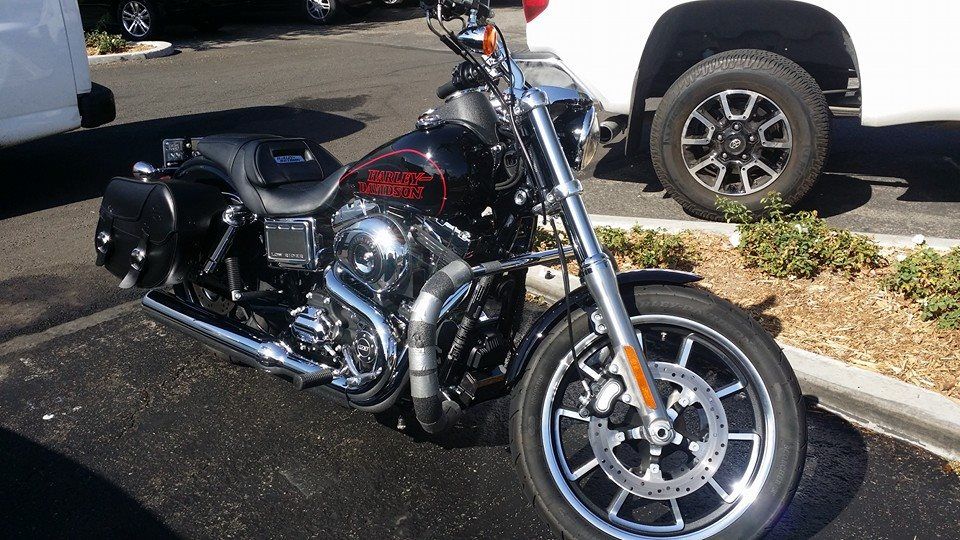 A harley davidson motorcycle is parked in a parking lot next to a white truck.