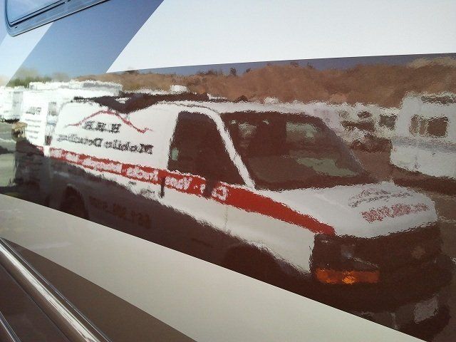 A white van with a red stripe on the side is parked in a parking lot