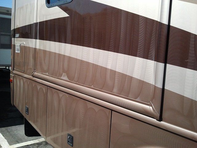 A brown and white striped van is parked in a parking lot