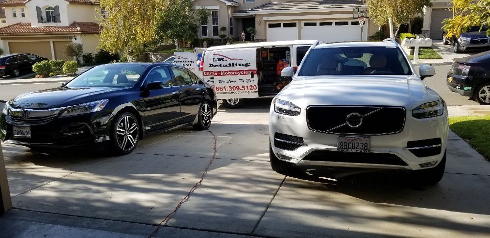 Two cars are parked next to each other in a driveway.
