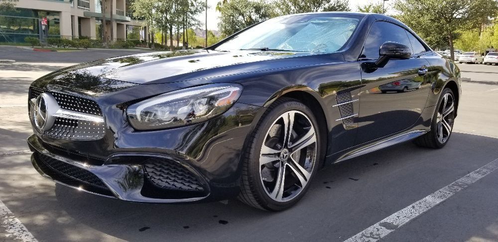 A black mercedes benz sl 500 is parked in a parking lot.