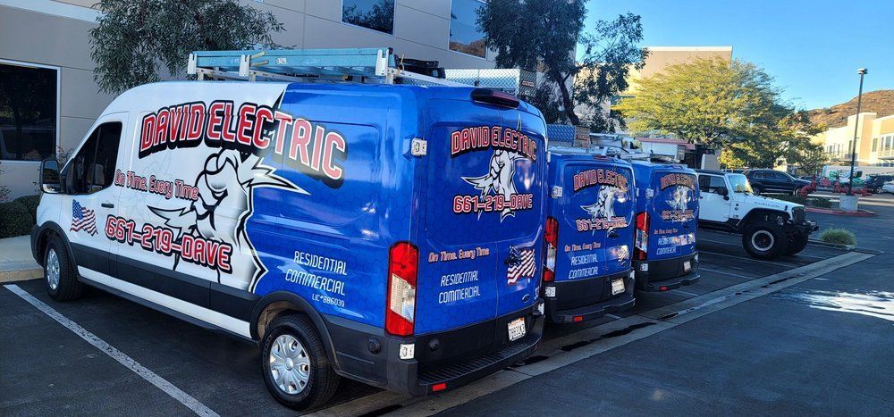 A row of blue and white vans are parked in a parking lot.