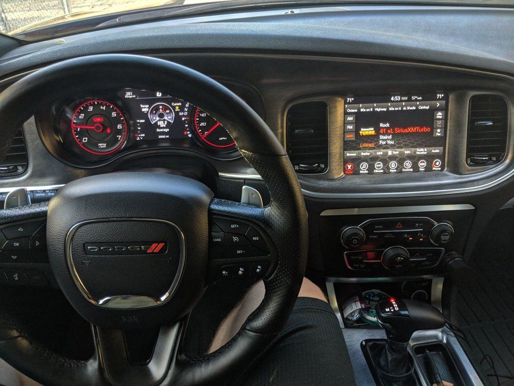 A person is sitting in the driver 's seat of a dodge charger.