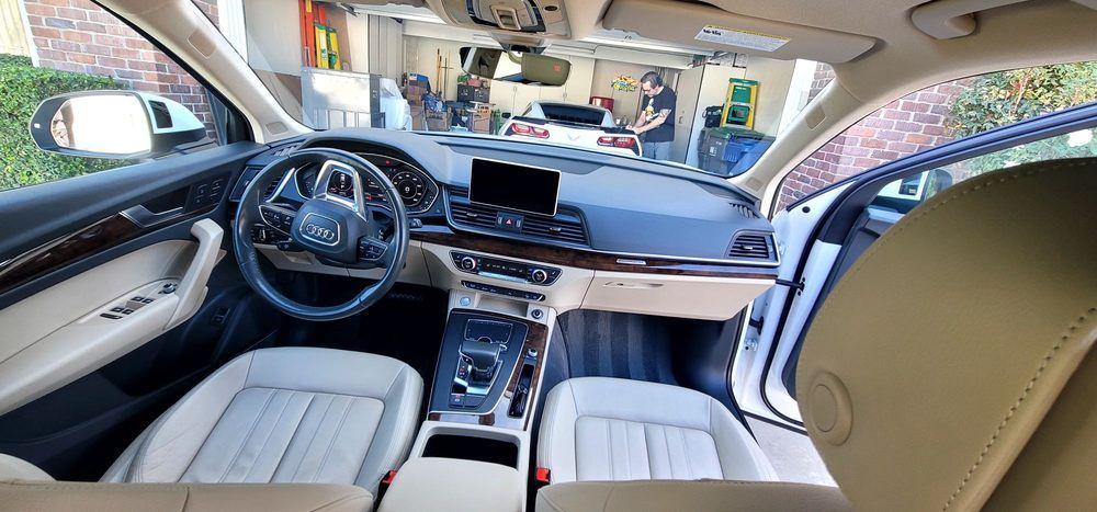 The inside of a car with a steering wheel and a dashboard.