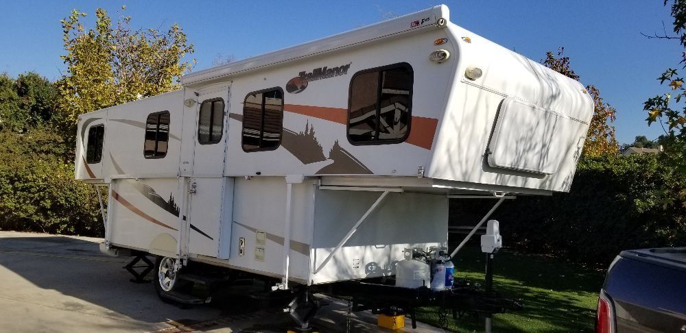 A white rv is parked on the side of the road