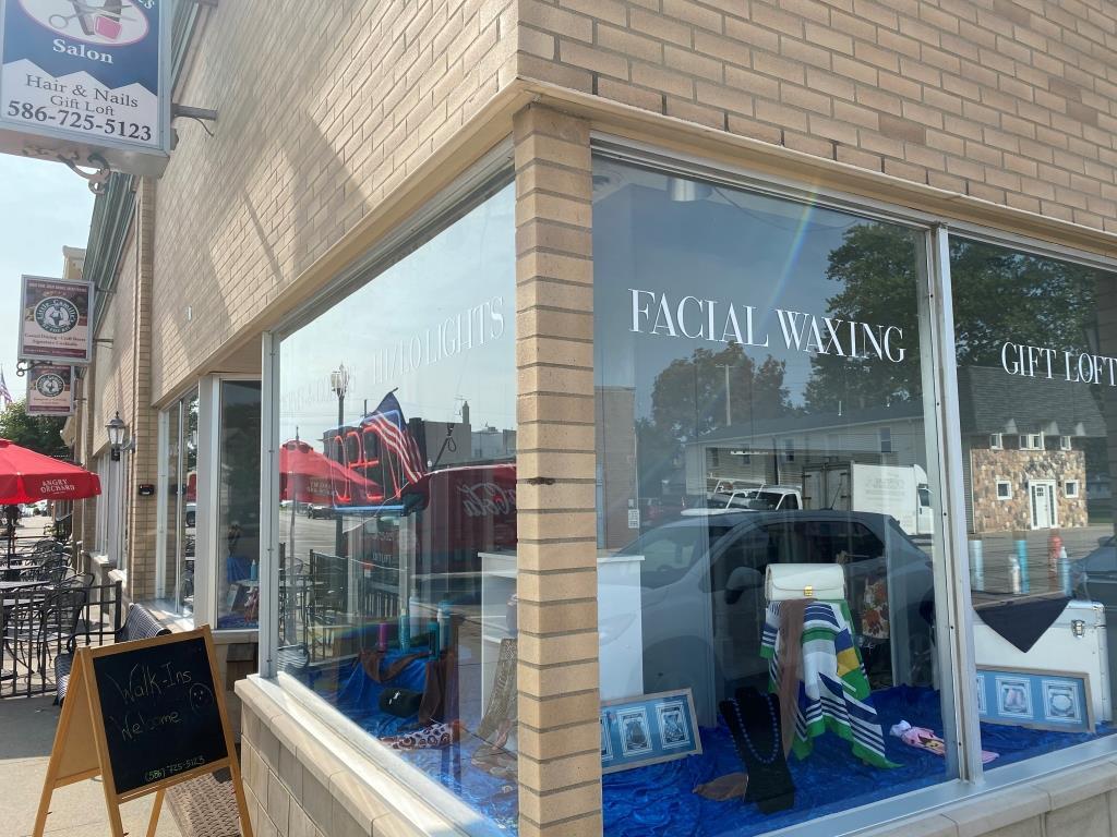 A brick building with a window that says facial waxing