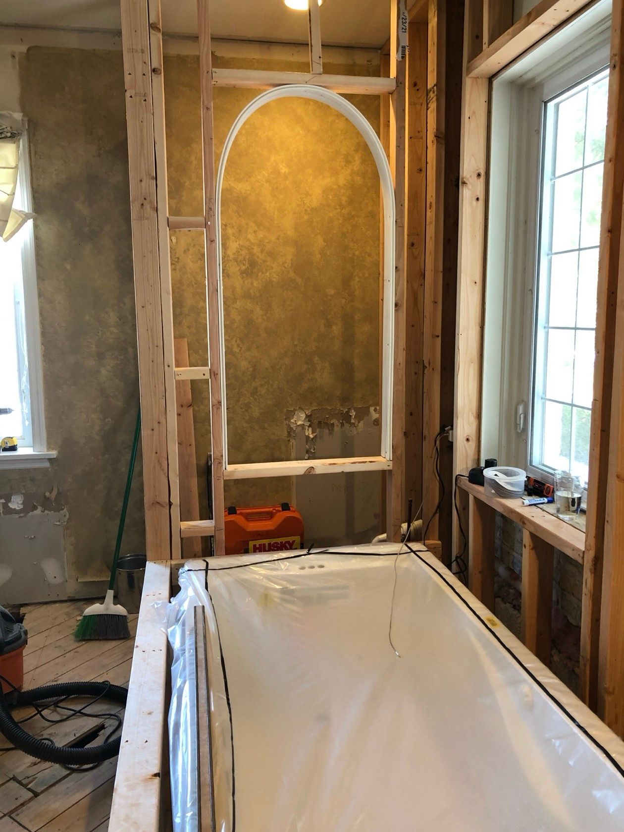 Bathroom remodel in progress: wooden framing around a tub, arched niche, and a window.