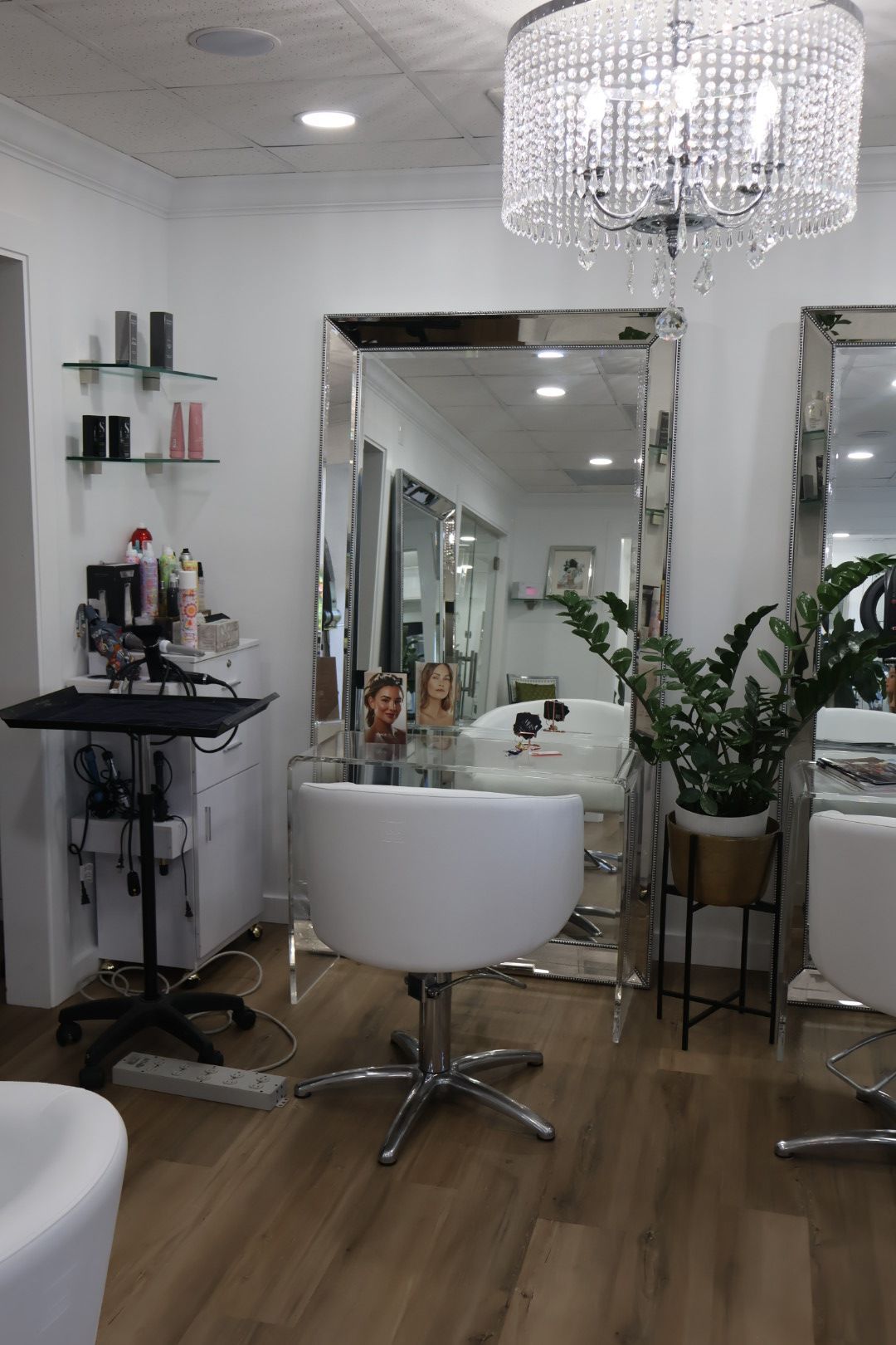 A hair salon with a large mirror and a white chair.