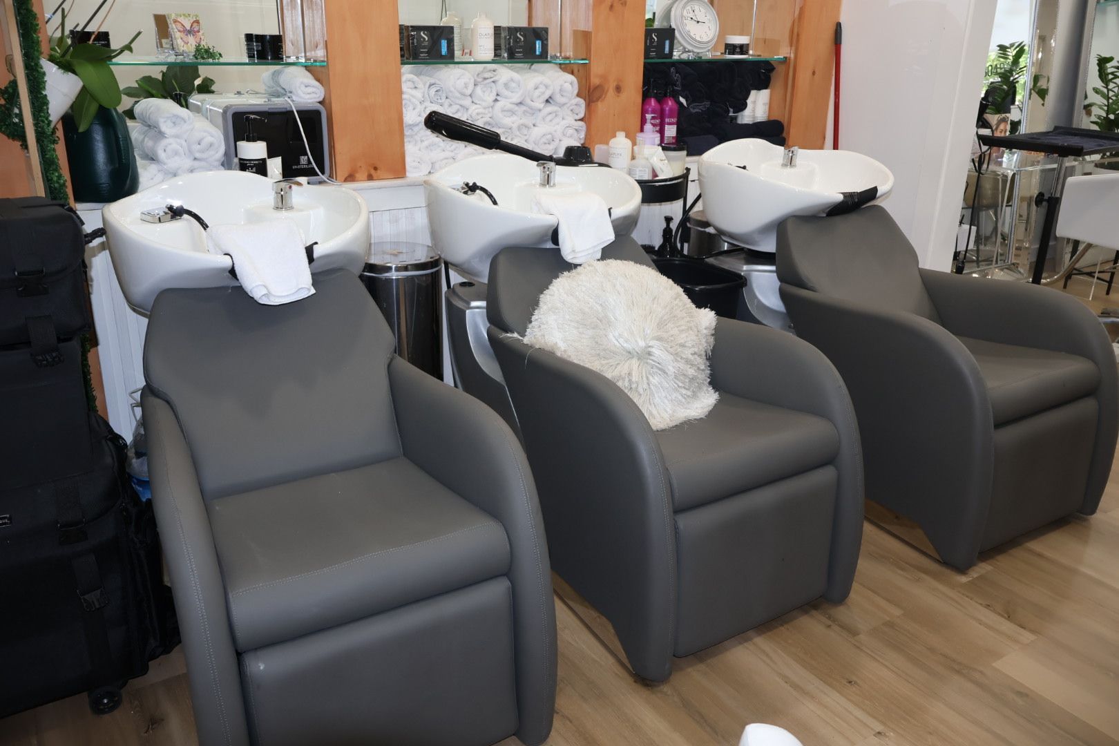 A row of chairs in a hair salon with sinks