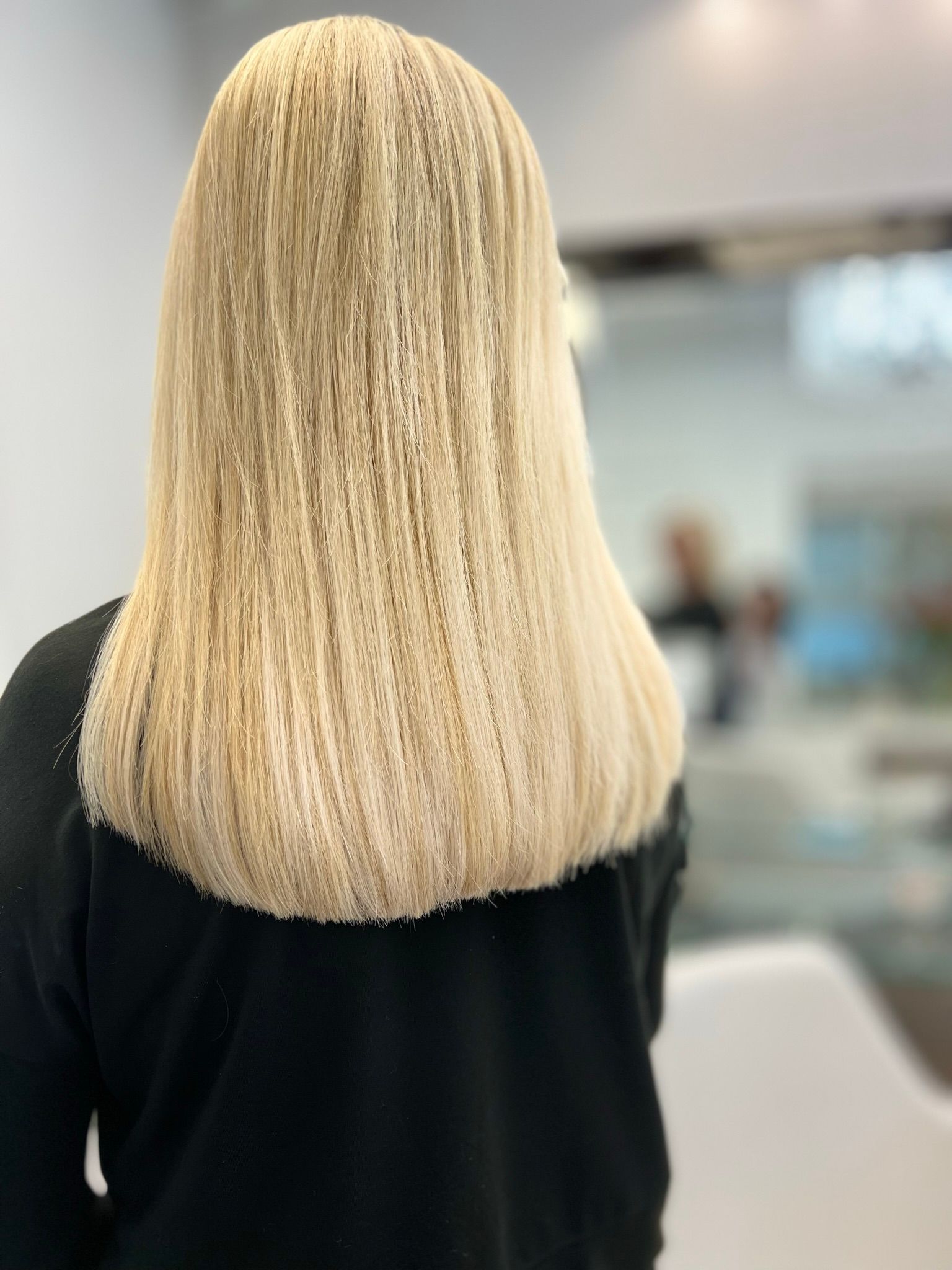 A woman with blonde hair is wearing a black shirt.